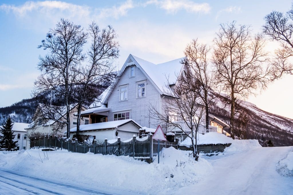 White wooden house in winter landscape of Nordic town Tromso, Norway.